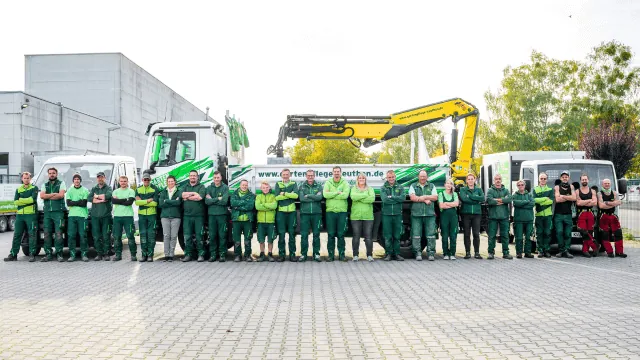 Team der GZA Gartenpflege Zeuthen mit Fuhrpark und Kranfahrzeugen auf dem Betriebshof